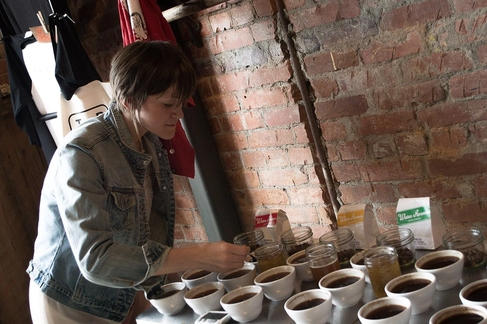 A taster checks cupping bowls of coffee