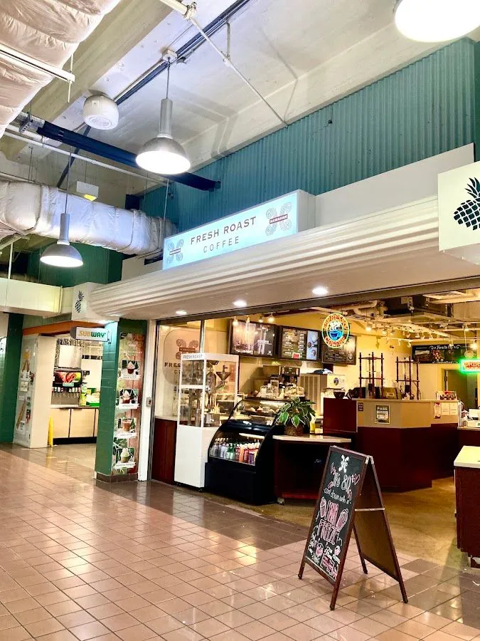 Indoor coffee counter under a Fresh Roast Coffee sign, beside a Subway, in a tiled food hall.