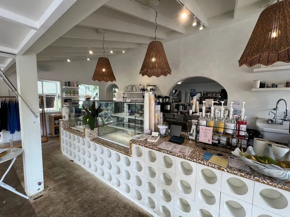 Service counter with circular breeze-block front, woven pendant lamps, pump bottles, and a glass display case.