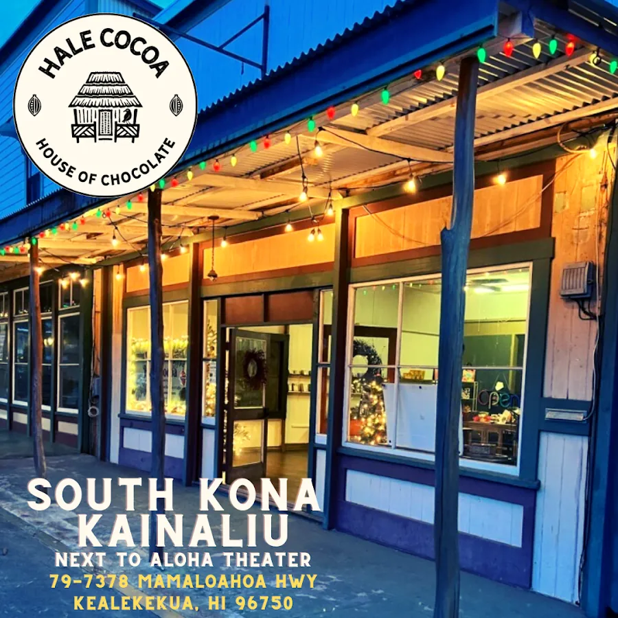 Wooden storefront at dusk with colored string lights, holiday windows, and Hale Cocoa signage.
