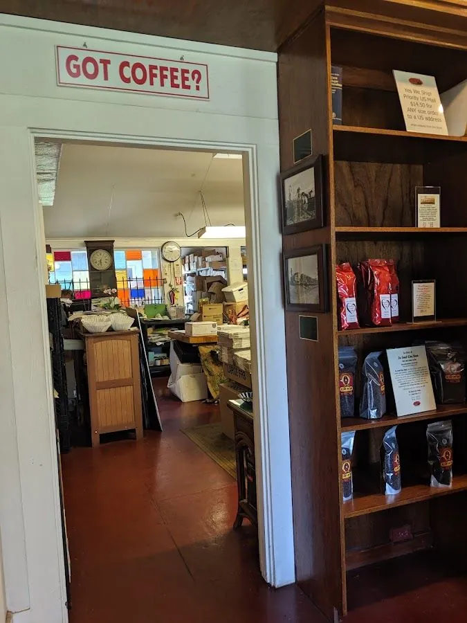 Open doorway under a GOT COFFEE? sign, with bagged coffee on a wood shelf and a cluttered room beyond.