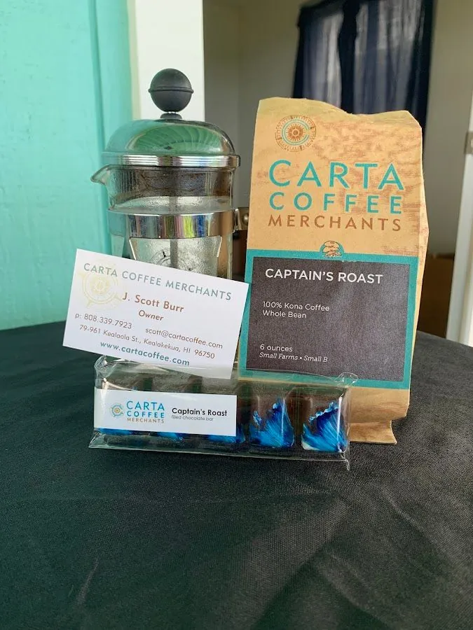 French press, Carta Coffee Merchants card, Captain's Roast coffee bag, and filled chocolate bar on dark cloth.