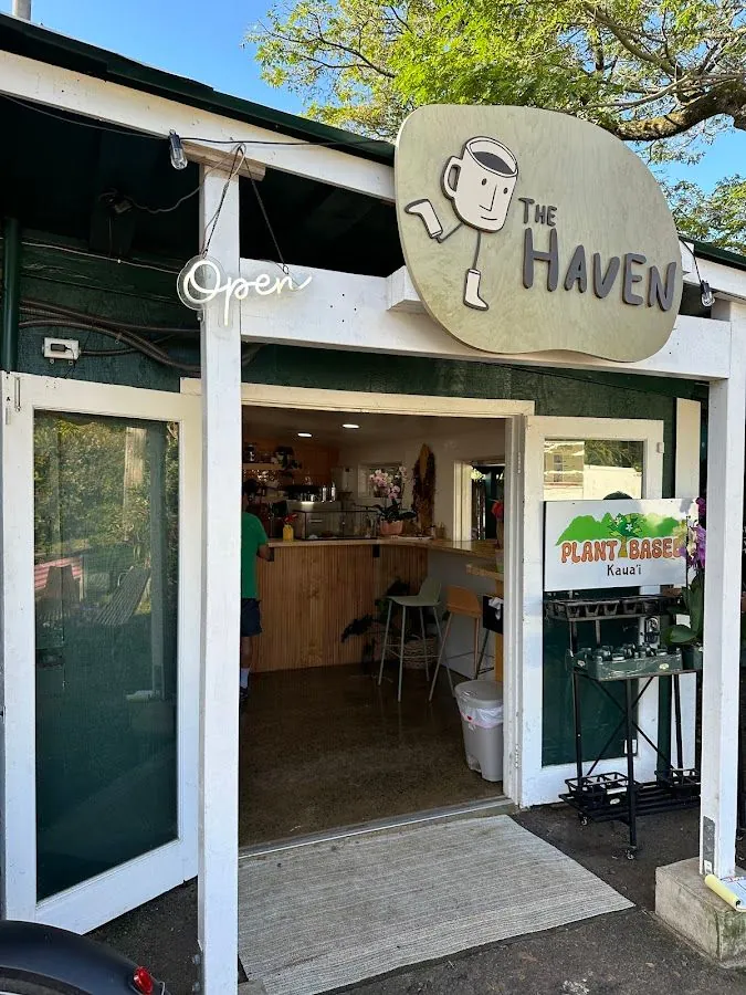 Green shopfront of The Haven with an Open sign, oval logo, and an open doorway.