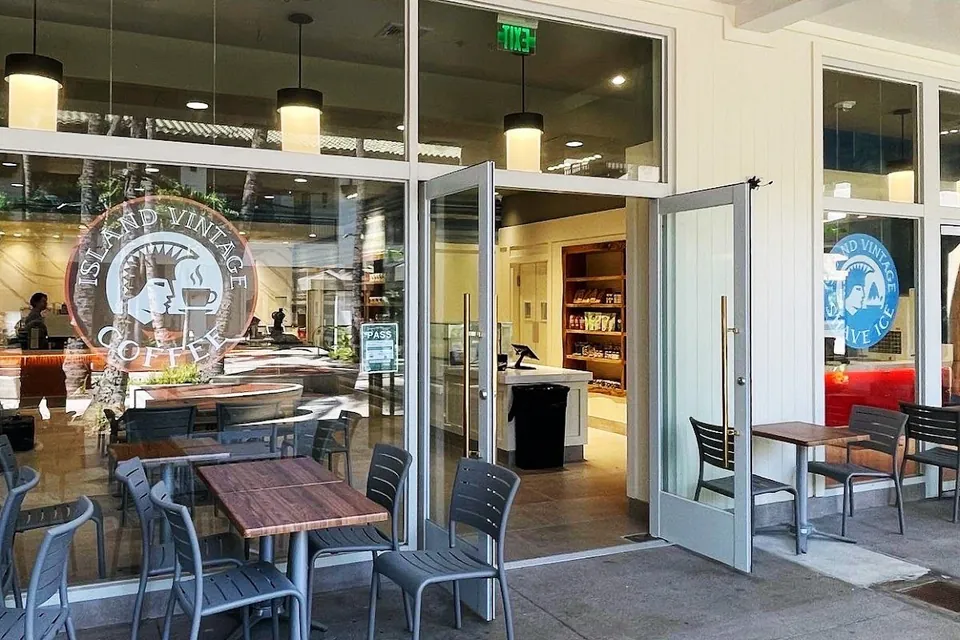 The Island Vintage Coffee storefront has open glass doors, patio tables, and window logos.