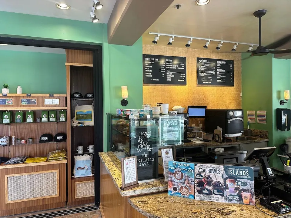 Coffee shop service counter with menu boards, retail shelves, and drink displays.