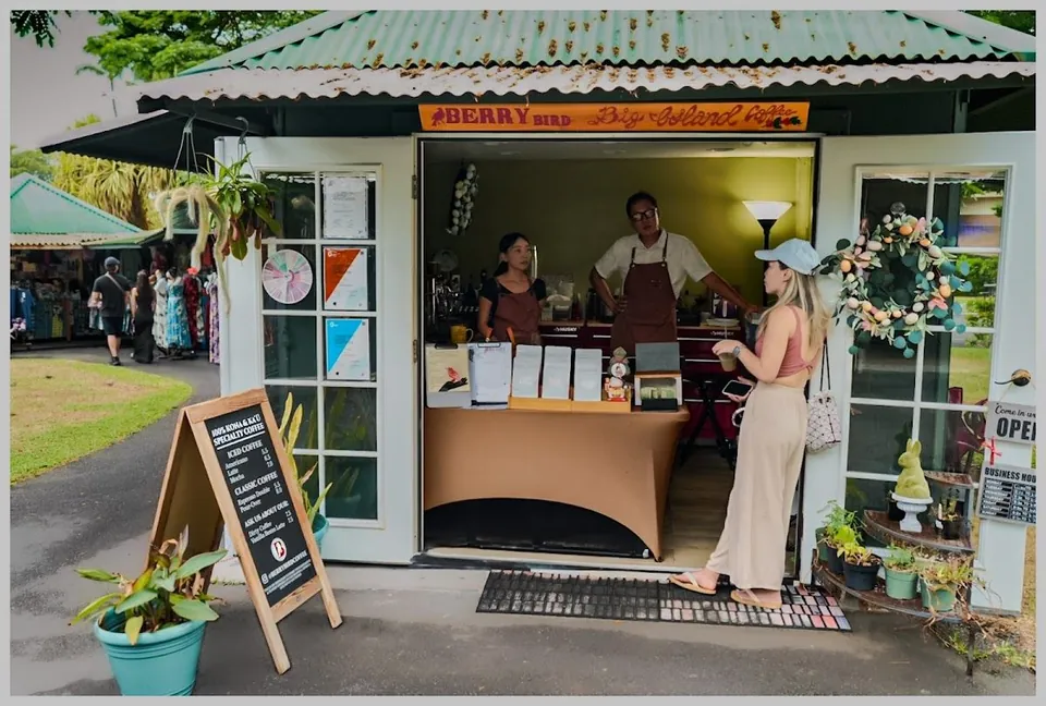 Green-roofed Berry Bird coffee kiosk with an open service window, chalkboard menu, and people at the counter.