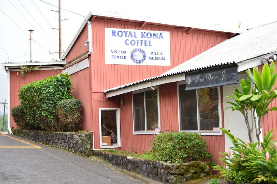 Coral building signed Royal Kona Coffee Visitor Center and Mill & Museum, with a Maui Divers Jewelry banner.