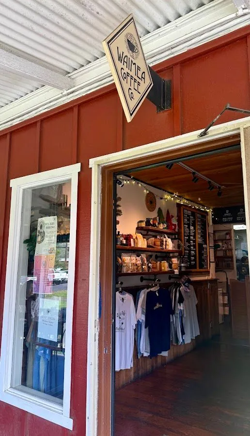 Red shopfront under a corrugated roof, with a Waimea Coffee Co. sign above an open doorway into the shop.